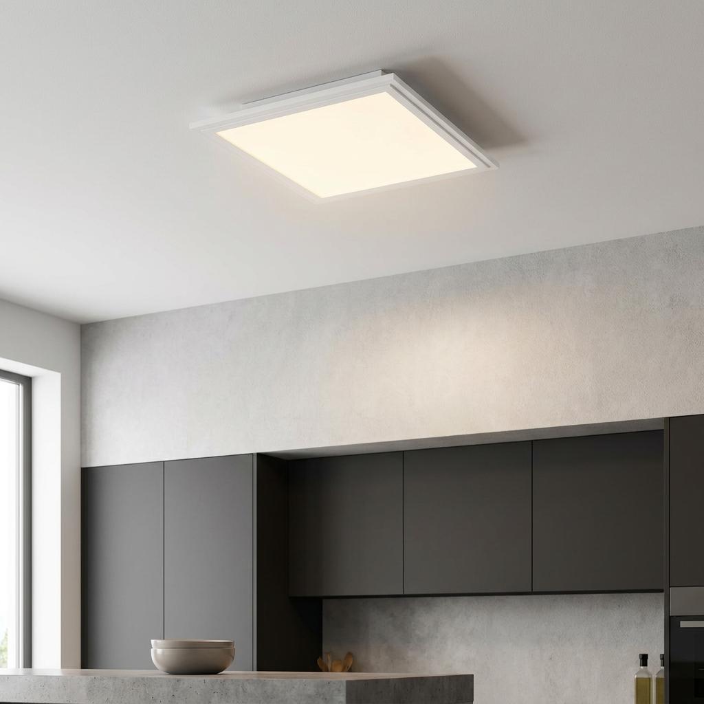 Square LED panel flush ceiling light glowing in a modern kitchen with dark grey cabinetry and light grey walls.