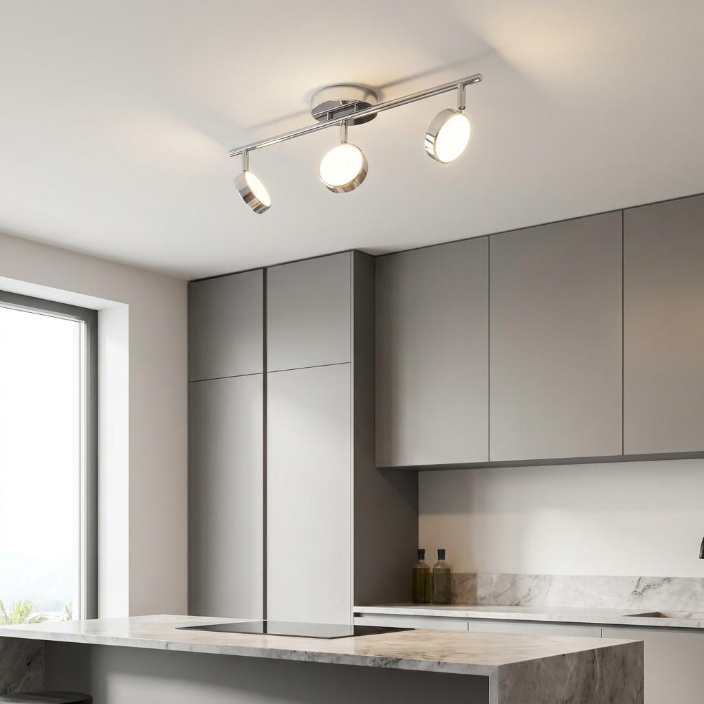 Eglo Salto Chrome LED 3 Light Bar Spotlight illuminated on a kitchen ceiling above a marble island and grey cabinets.