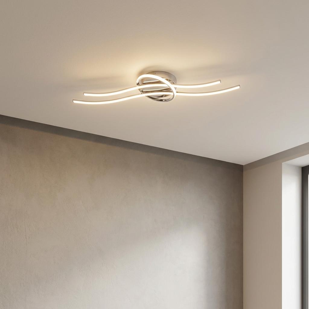 Modern chrome flush ceiling light with wave-like LED arms mounted on a plain white ceiling in a room.