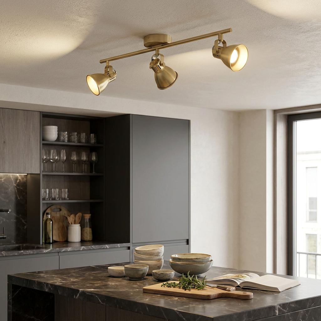 Eglo Seras brass 3-light bar spotlight illuminates a modern kitchen with a dark marble island.