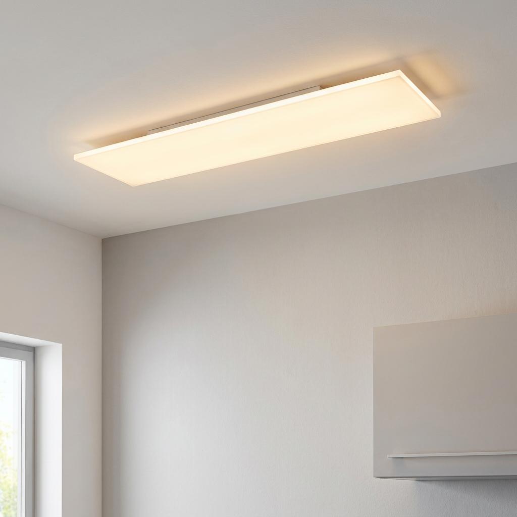 Slim rectangular white LED ceiling panel emitting a warm glow in a modern room.