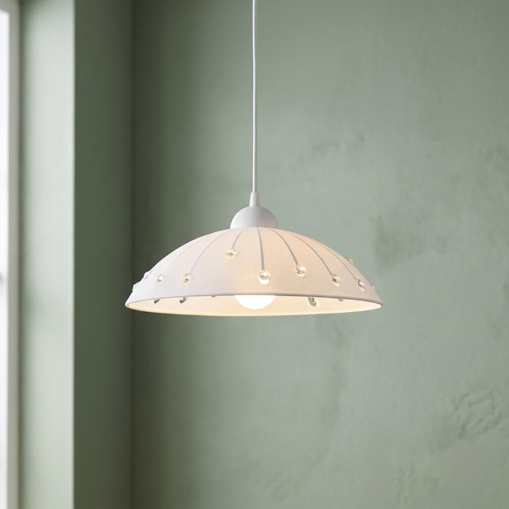 A white satin glass dome pendant light with crystal accents hanging in a room with green walls.