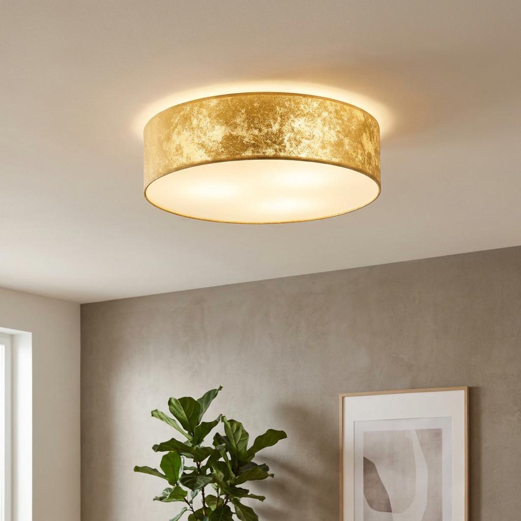 Round gold leaf style flush ceiling light with a frosted diffuser illuminating a modern interior room.