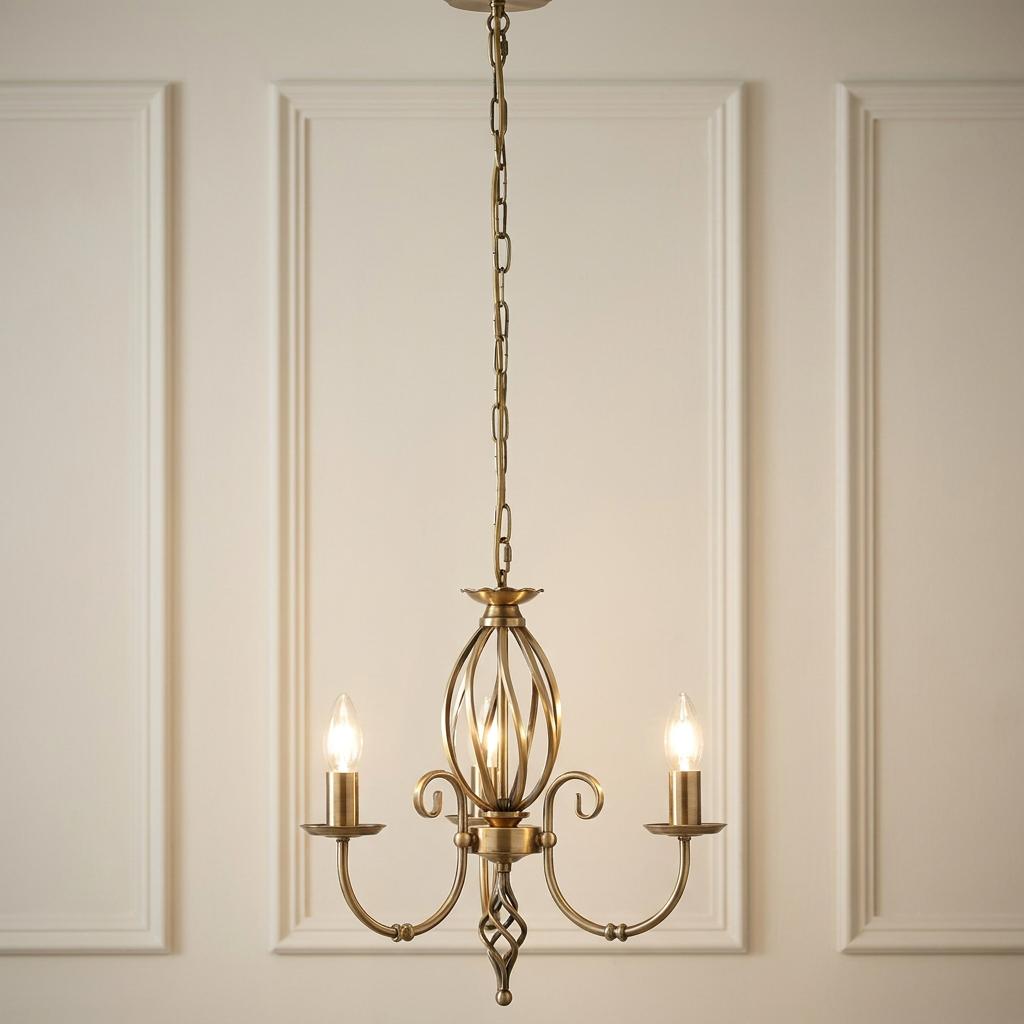 Elstead Artisan 3-light aged brass chandelier with scroll arms and birdcage detail against a paneled wall.