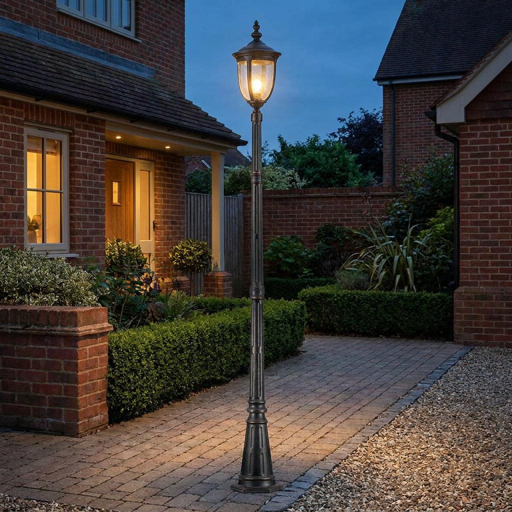 Elstead Cleveland bronze single head lamp post lighting a brick path in a garden at twilight.