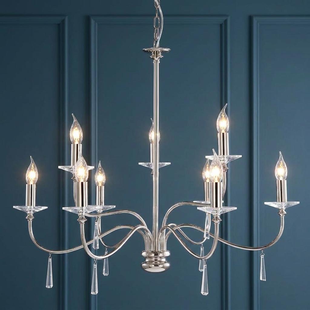 Elegant 9-light polished nickel chandelier with crystal accents and candle bulbs against a blue paneled wall.