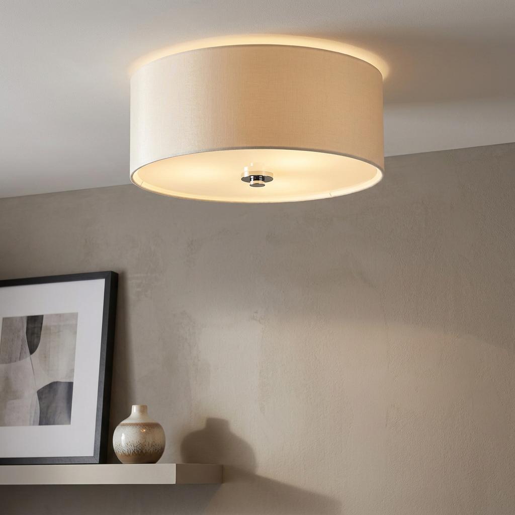 Elstead Fletcher 18 Flush Drum Shade with a beige fabric finish and polished chrome finial against a tan wall.