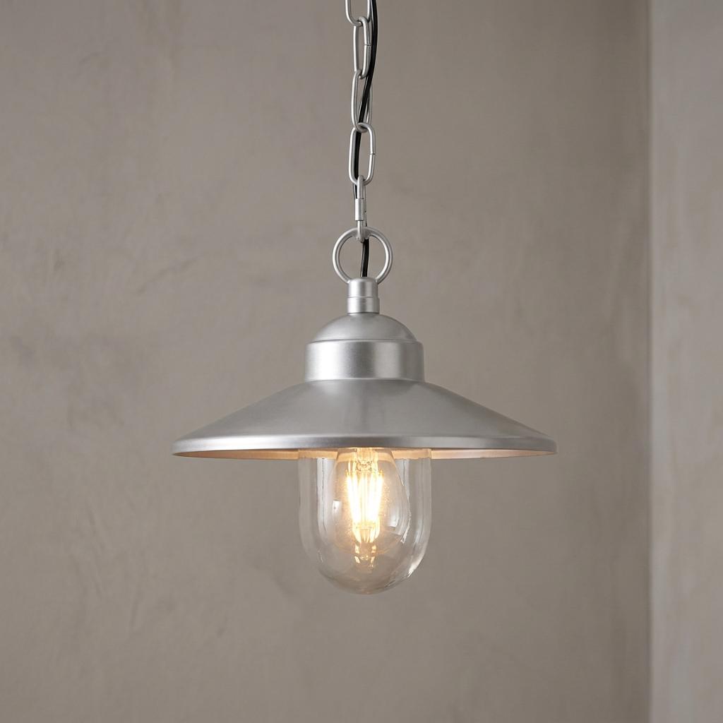 Elstead Klampenborg silver outdoor pendant light with a metal shade and glass-enclosed lit bulb against a neutral wall.