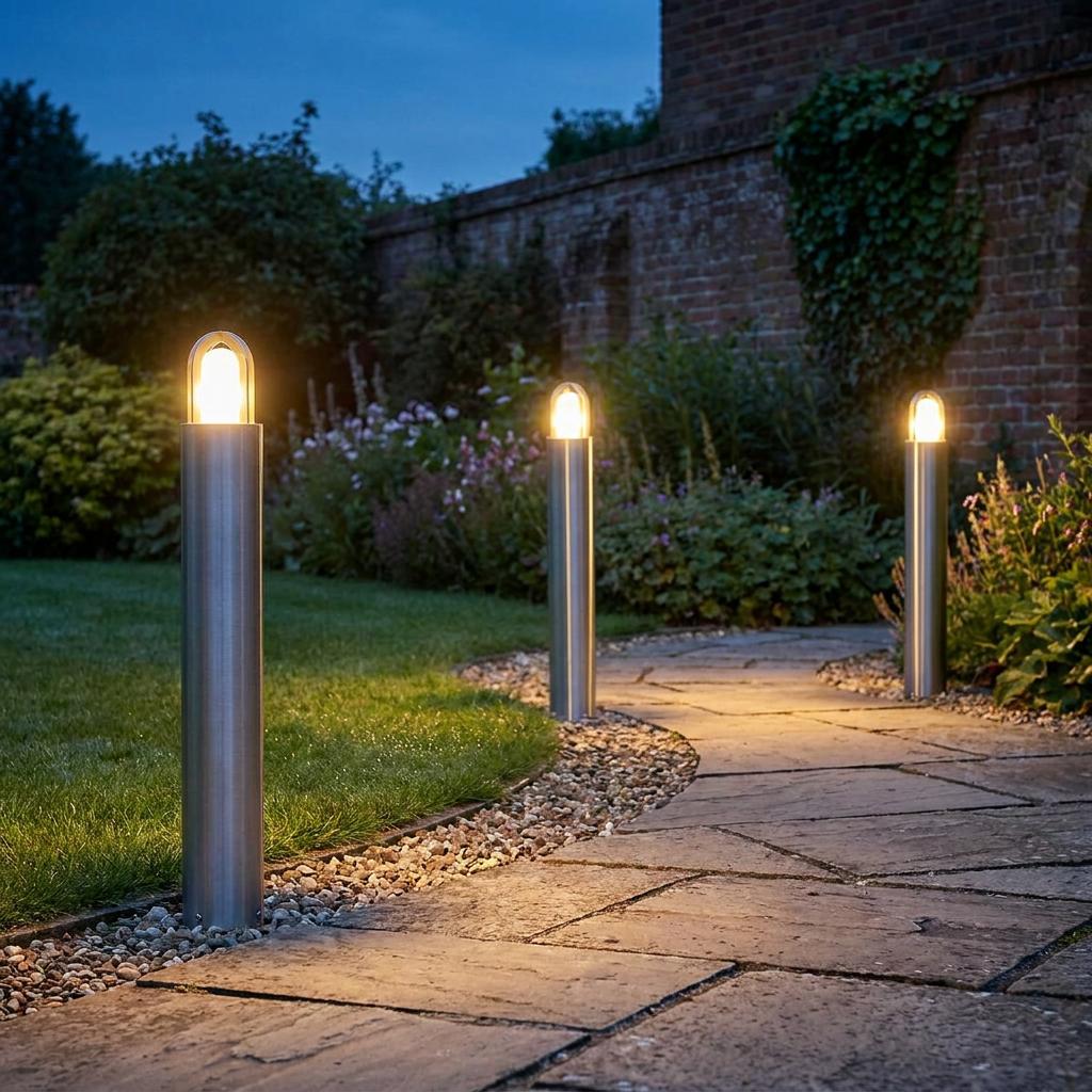 Silver Elstead Paignton bollard lights illuminating a winding stone garden path at dusk.