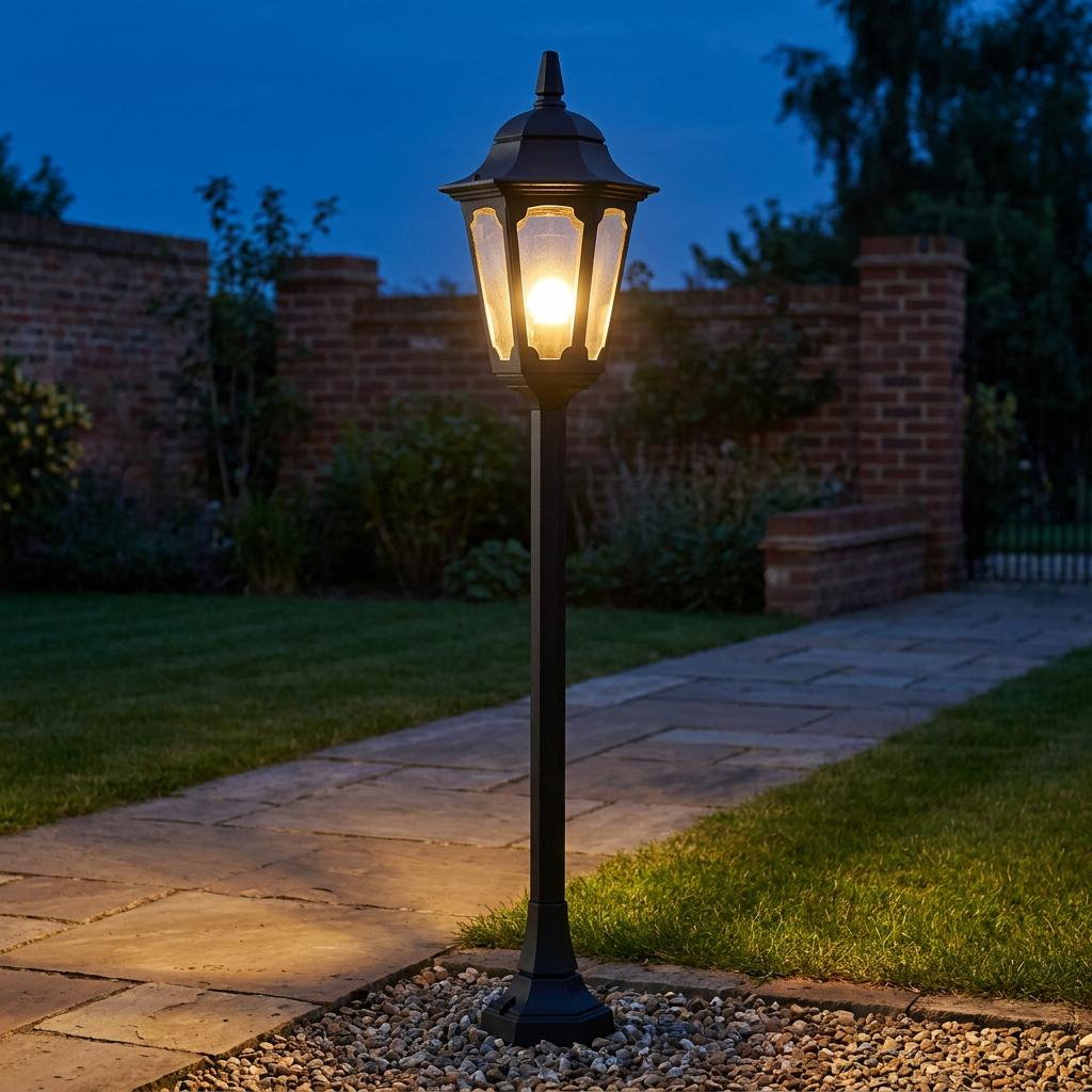 Classic black Elstead Parish outdoor bollard light illuminating a garden pathway at twilight.