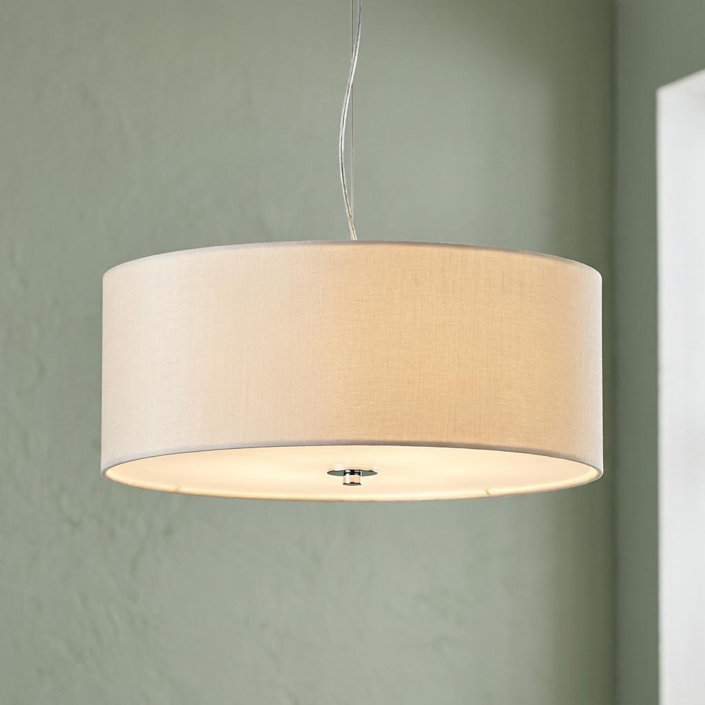 Modern cream fabric drum pendant light with a bottom diffuser hanging against a sage green wall.