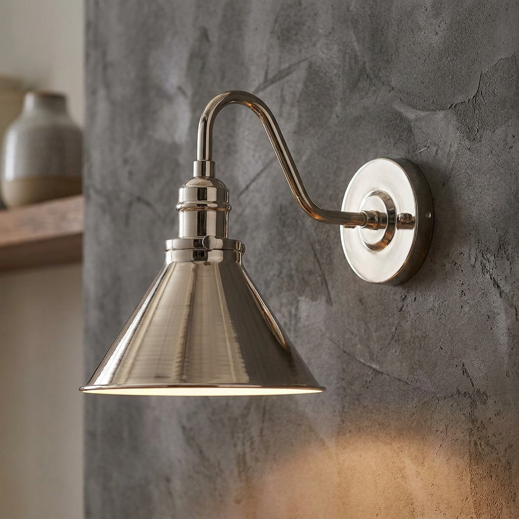 Polished chrome wall light with a conical shade and swan neck arm mounted on a textured grey plaster wall.