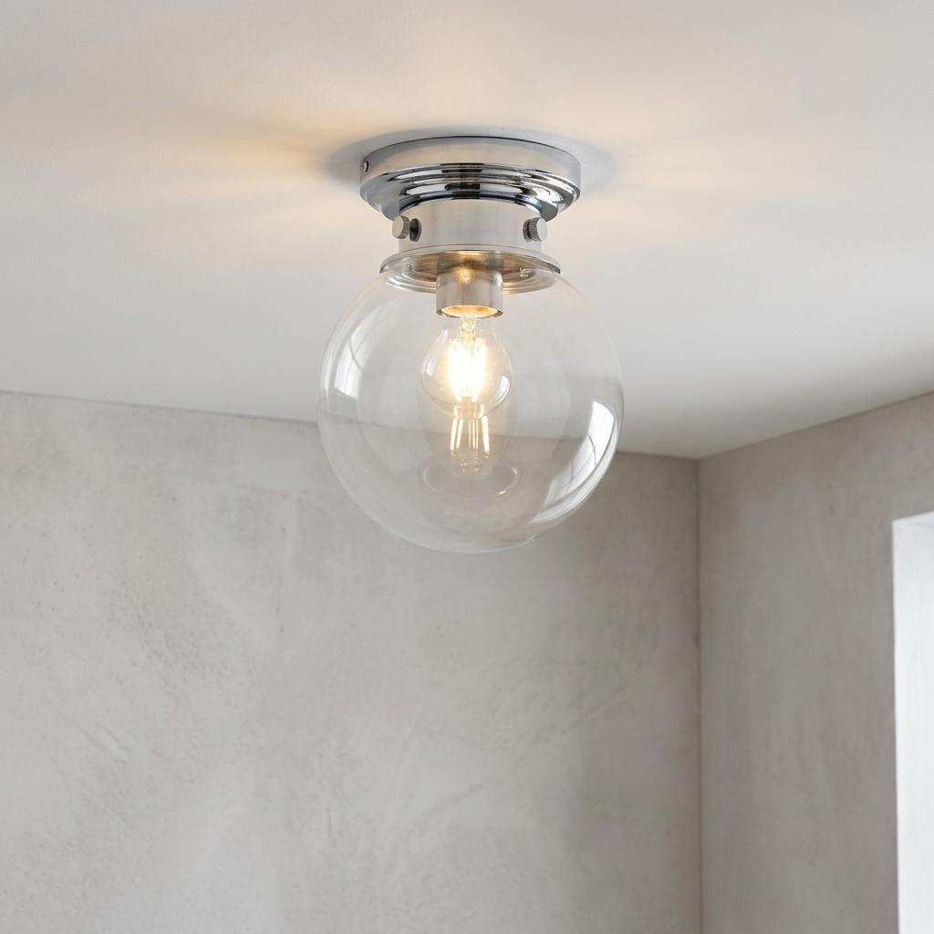 Modern flush bathroom ceiling light with a clear glass sphere and polished chrome mount.