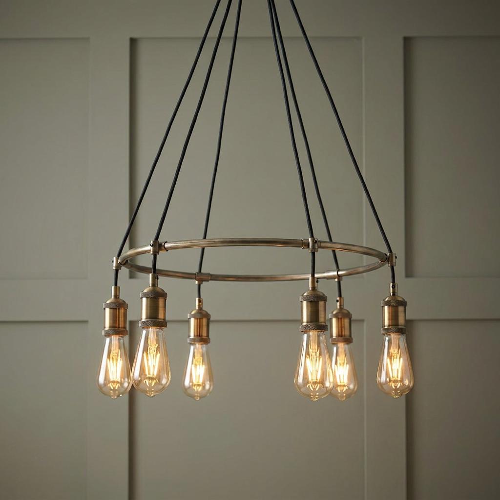 Endon Hal 6-light antique brass pendant ceiling light with exposed Edison bulbs against a green paneled wall.