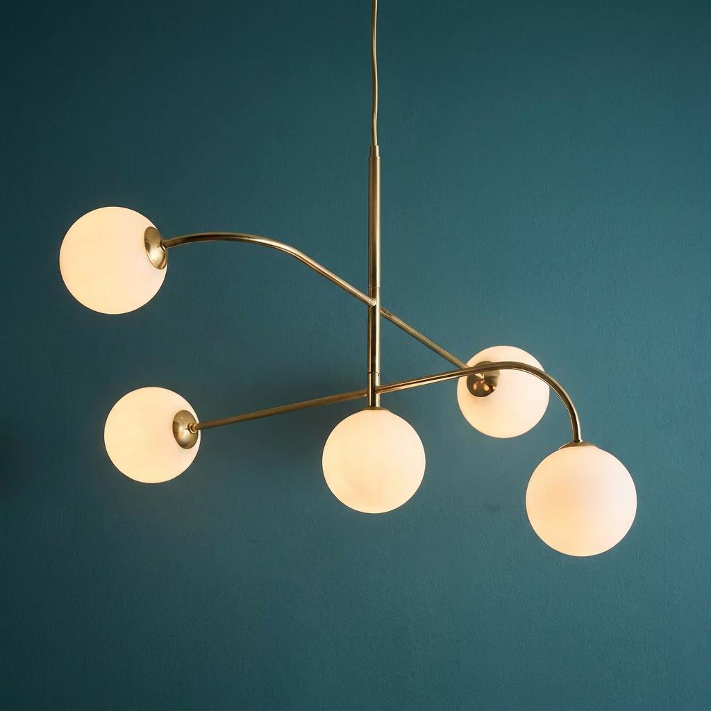 Endon Otto five-light brass semi-flush ceiling light with frosted glass globes against a dark teal wall.