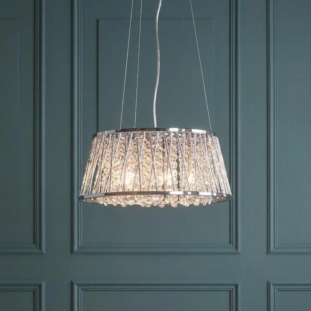 Endon Sophia 5-light chrome and crystal pendant with a wire mesh shade against a teal paneled wall.