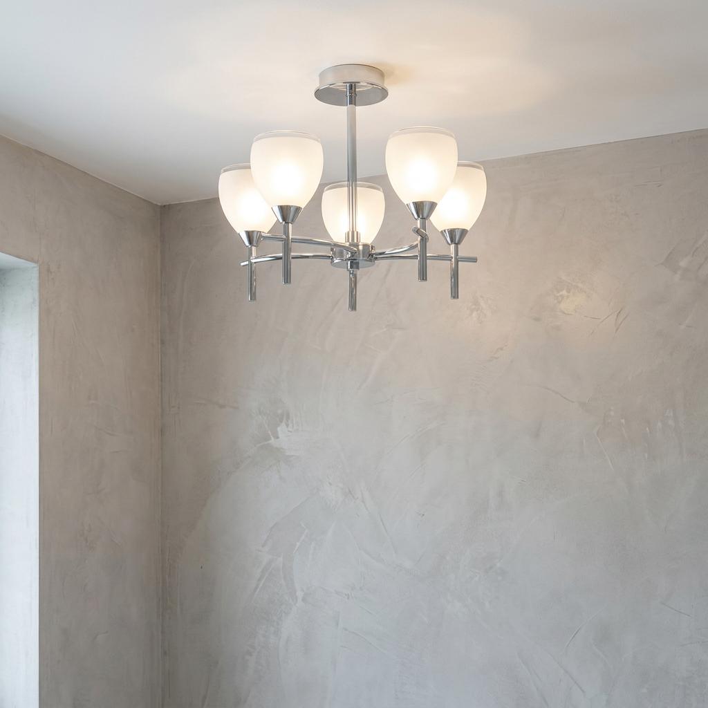 Etta chrome 5-light semi-flush bathroom ceiling light with frosted glass shades against a grey textured wall.