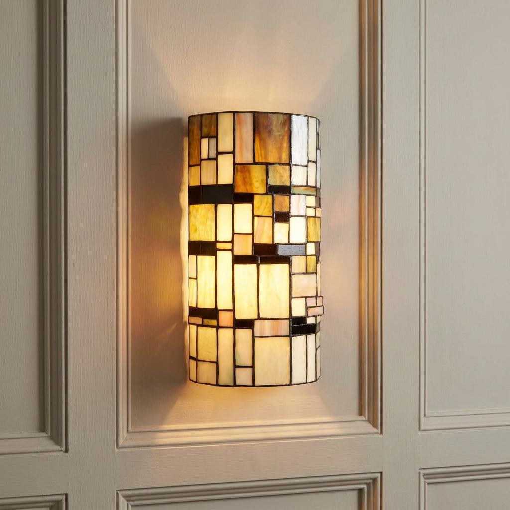 Geometric Tiffany wall light with amber and cream glass panels mounted on a light paneled wall.