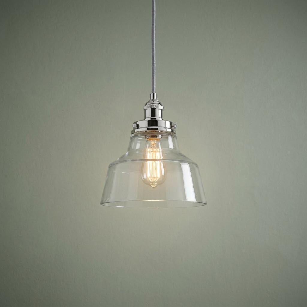 Feiss Baskin polished nickel ceiling pendant with clear glass bell shade and vintage bulb against a green wall.