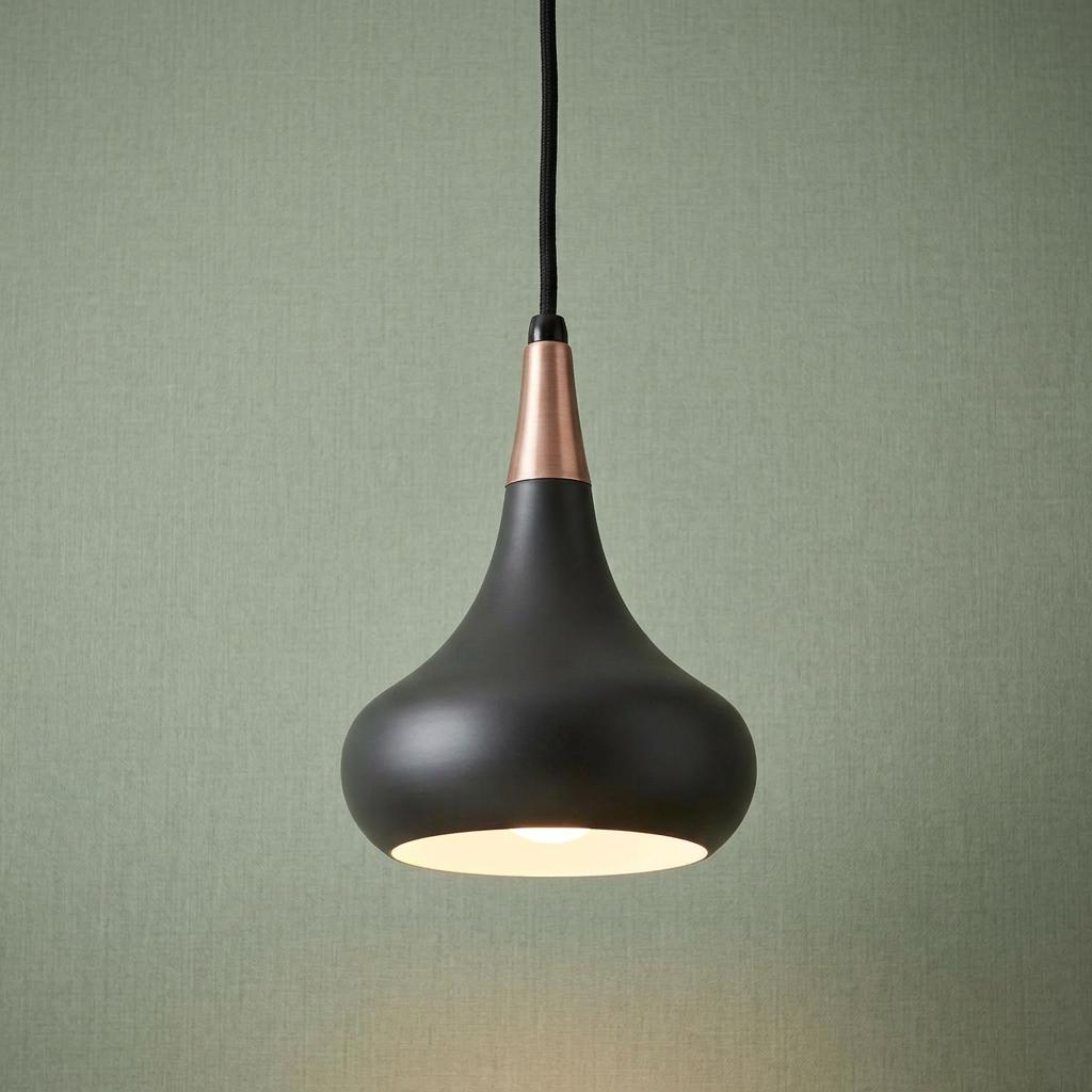 Modern dark bronze teardrop pendant light with copper accent hanging against light green wallpaper.