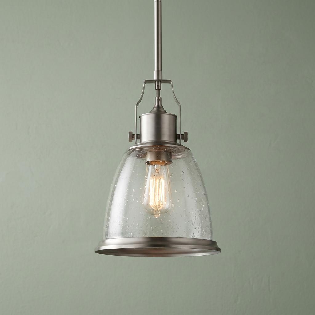 Feiss Hobson medium ceiling pendant with a seeded glass shade and satin nickel finish against a green wall.