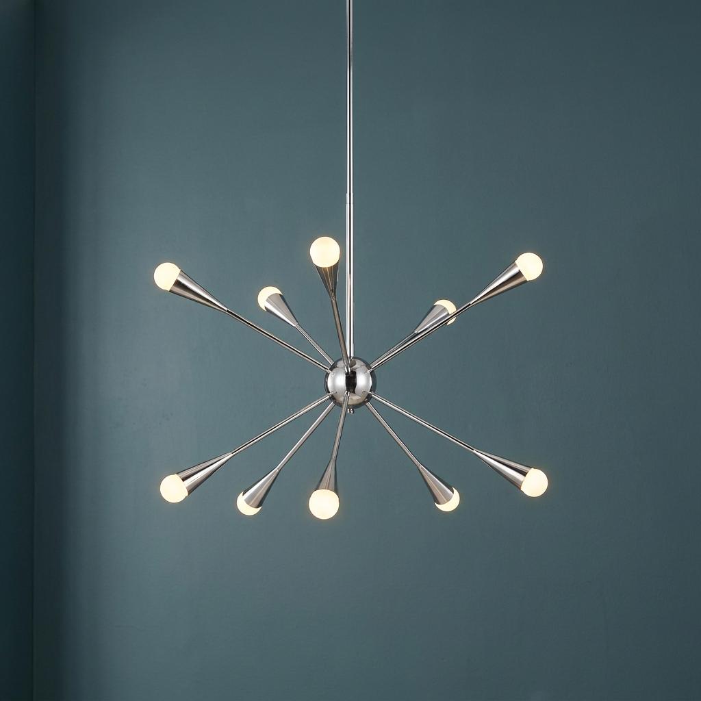 Feiss Jax 10-light polished nickel Sputnik chandelier with glowing globe bulbs against a dark teal wall.