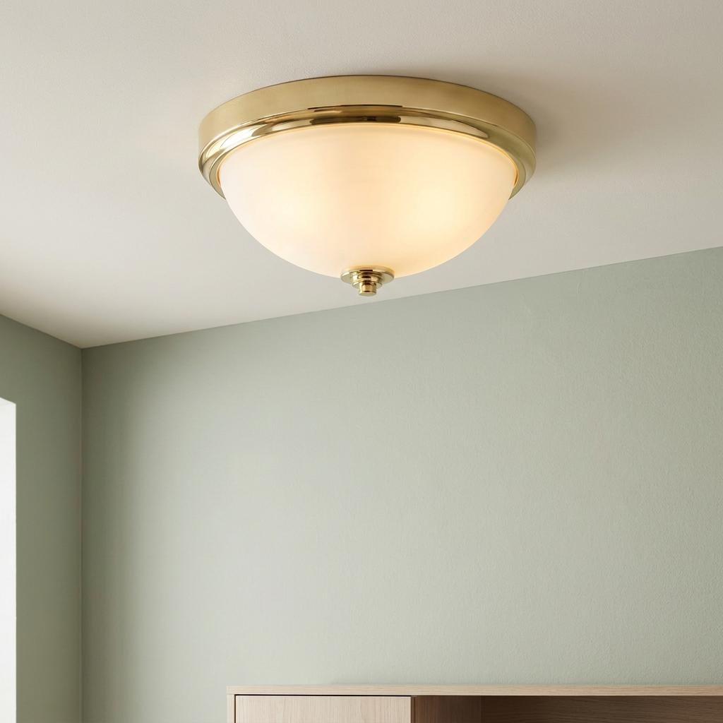 Feiss Malibu 2-light flush mount bathroom light with polished brass trim and opal glass bowl on a white ceiling.