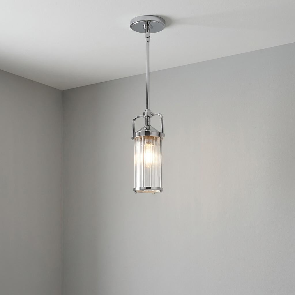 Chrome mini pendant light with a cylindrical ribbed glass shade hanging from a white ceiling.