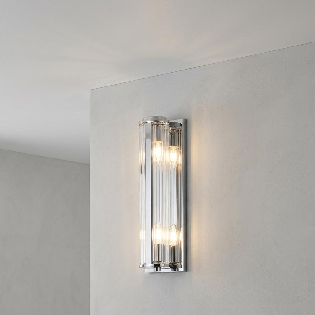 Modern 4-light wall sconce with vertical ribbed glass and chrome finish lit on a neutral wall.
