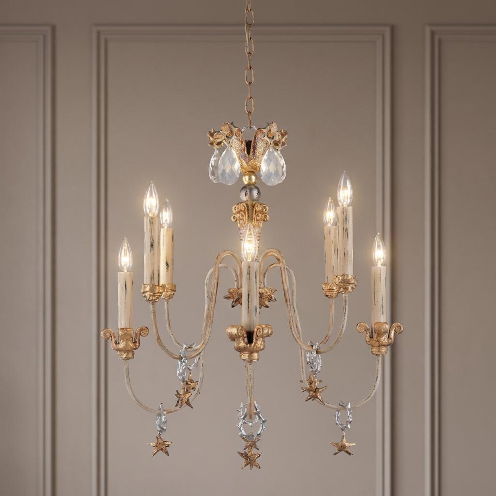 Ornate gold and silver 8-arm chandelier with candle bulbs and star charms against a neutral paneled wall.