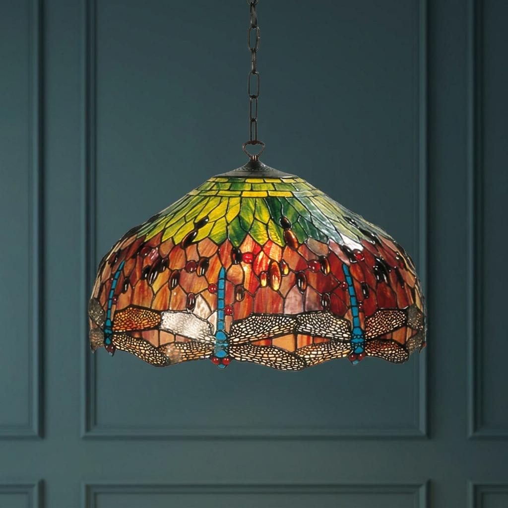 Flame Dragonfly Tiffany pendant light with a colorful stained glass shade against a dark teal paneled wall.