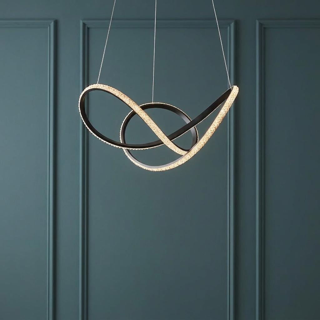 Interwoven black LED pendant with glowing faceted crystals against a dark teal wainscoted wall.