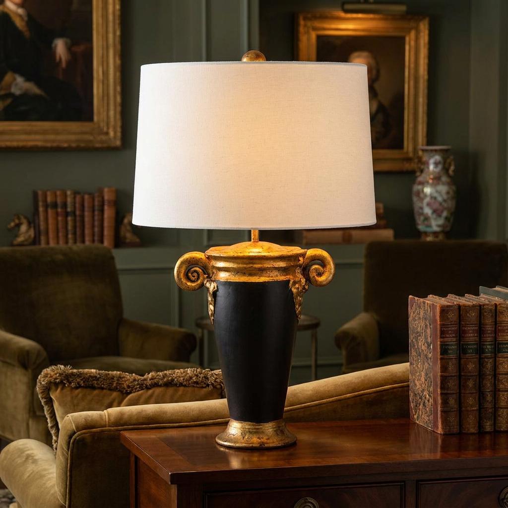 Gallier black and gold urn table lamp with a white drum shade glowing in a classic library setting.