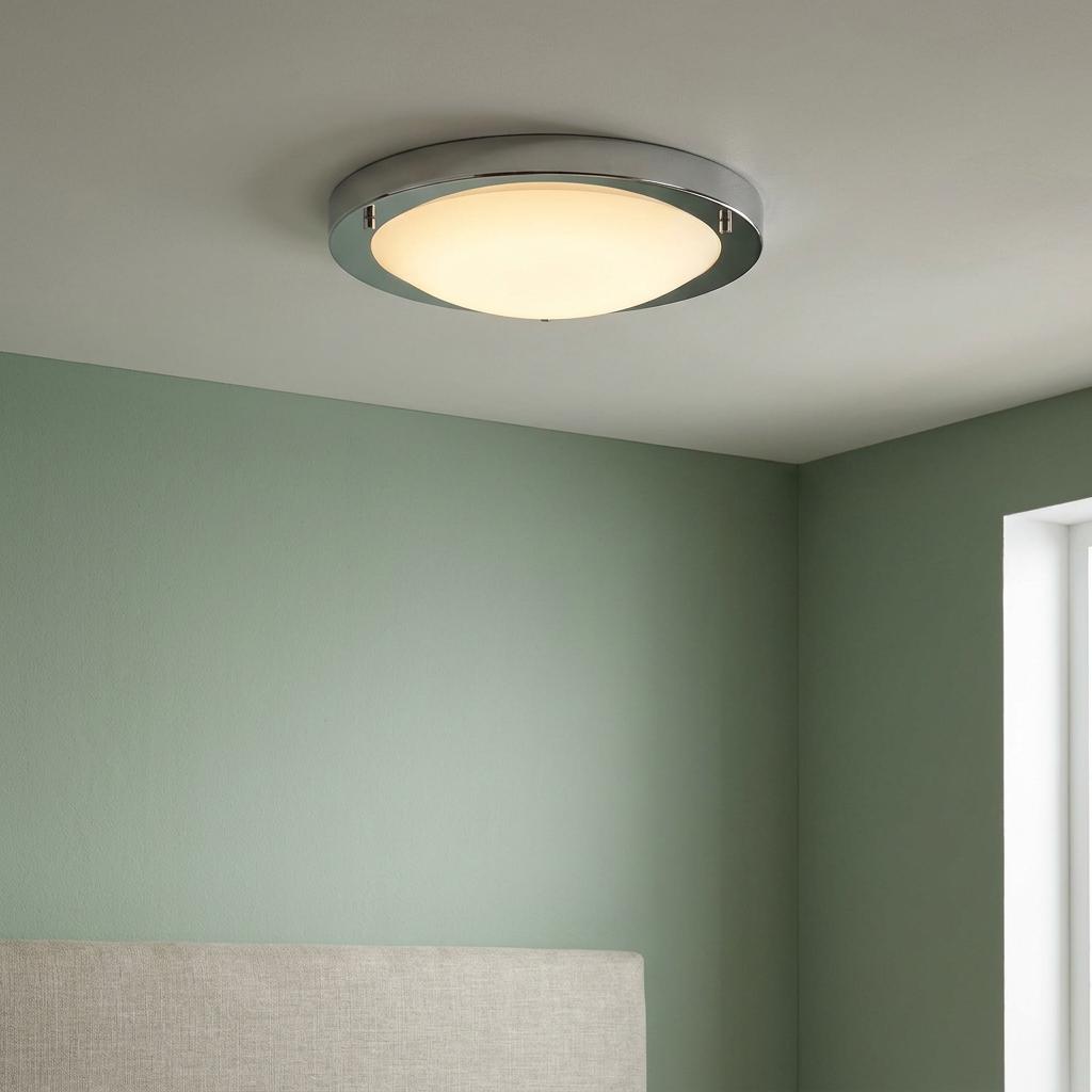 Geneva LED 12W silver flush ceiling light with an opal glass diffuser illuminated in a green-walled bedroom.