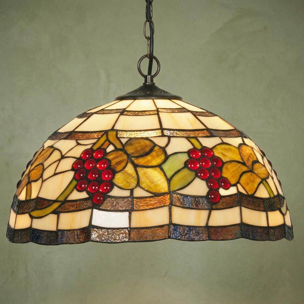 Grapes Tiffany pendant light with red glass beads and green leaves hanging against a textured green background.