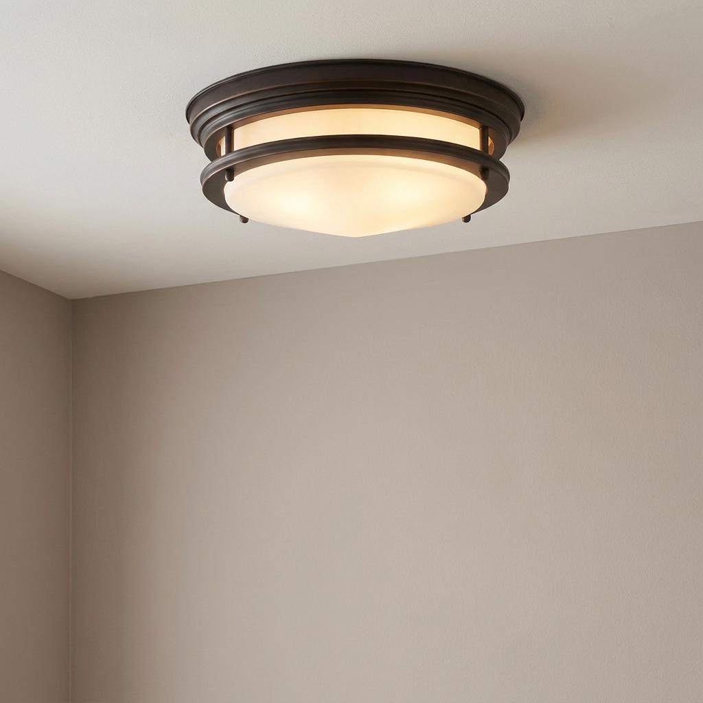 Hadrian oil-rubbed bronze flush mount ceiling light with opal glass shade installed on a neutral-toned ceiling.