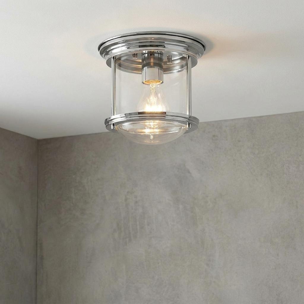 Hadrian flush bathroom ceiling light in chrome and clear glass mounted against a white ceiling and grey wall.