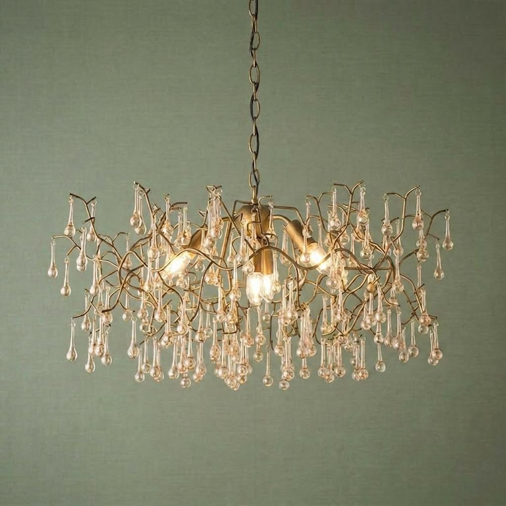 Gold 4-light pendant with a branch-like frame and glass teardrops, glowing against a textured green background.