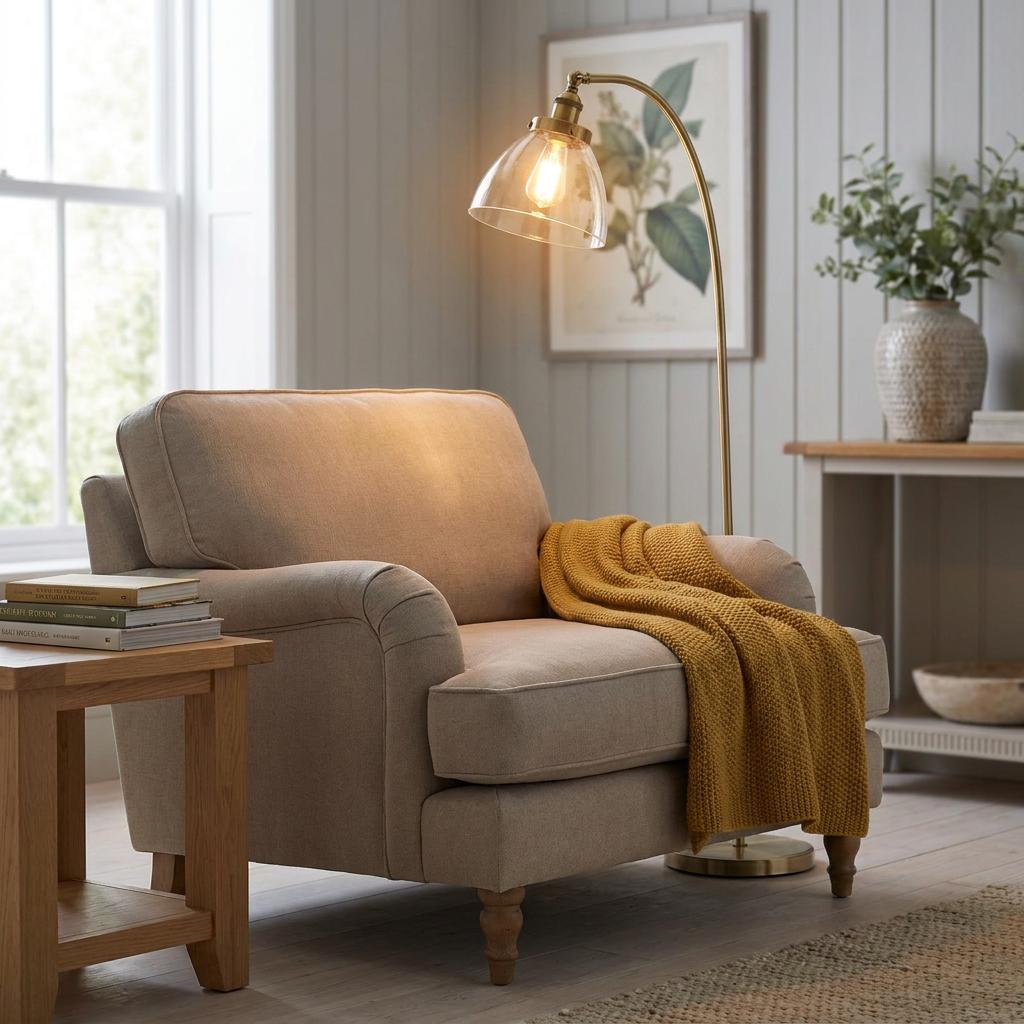 Arched Hansen brass floor lamp with a clear glass shade over a beige armchair in a cozy living room.