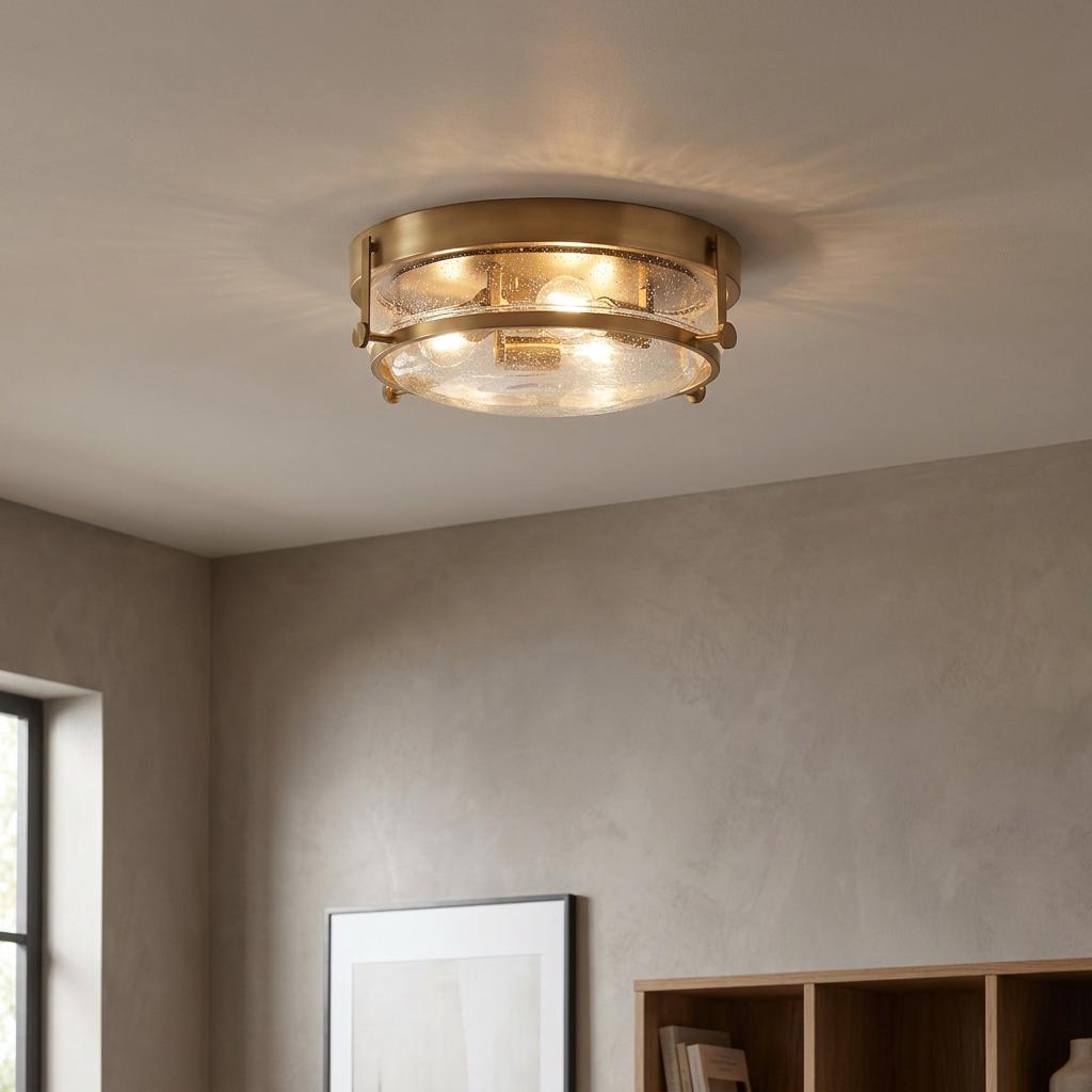 Harper 3 Light Brass Flush Ceiling Light with seeded glass, illuminated against a neutral ceiling in a modern room.