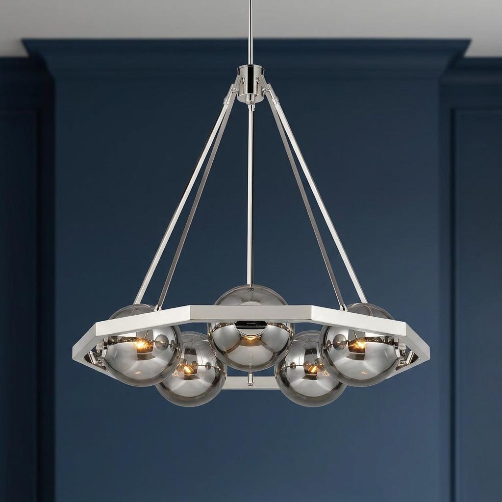 Modern five-light chandelier with a polished nickel frame and smoky glass globes against a deep blue wall.
