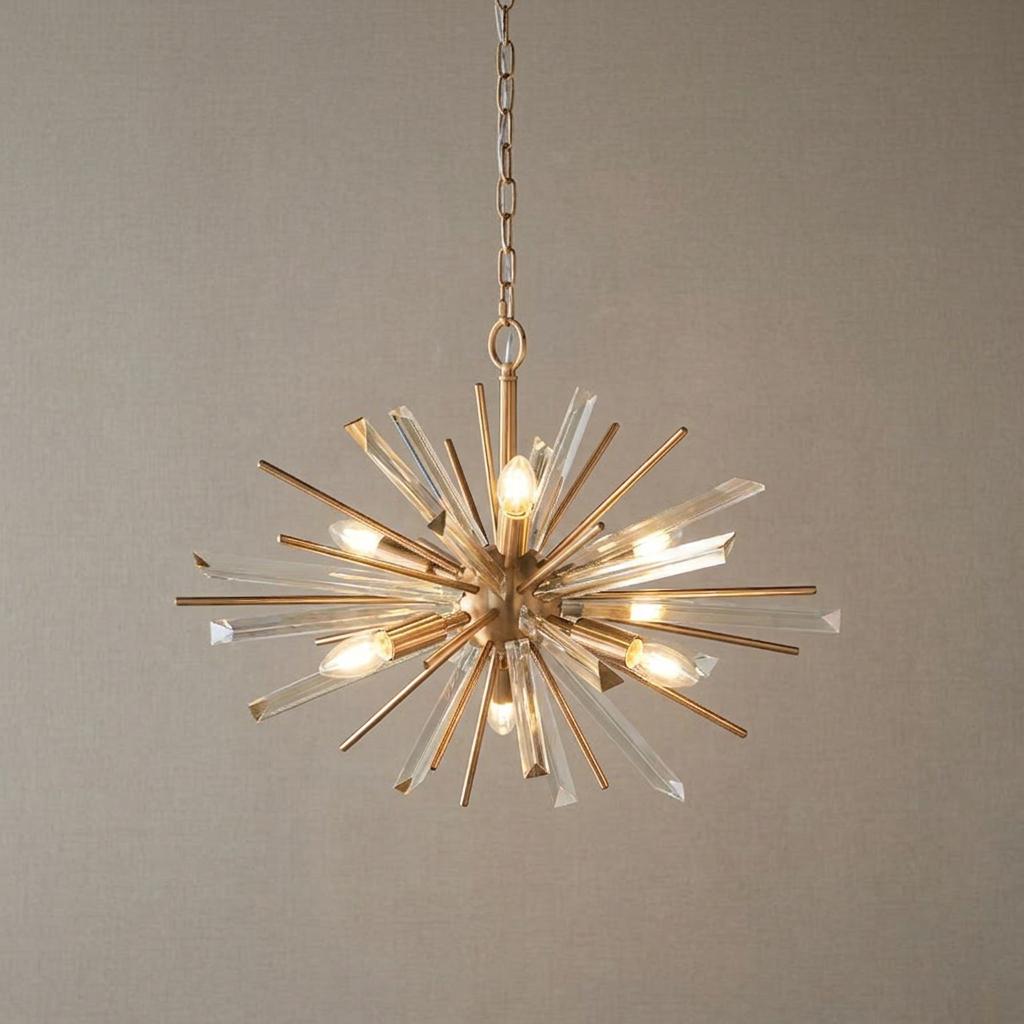 Antique brass starburst pendant light with glass prism shards hanging against a neutral wall.