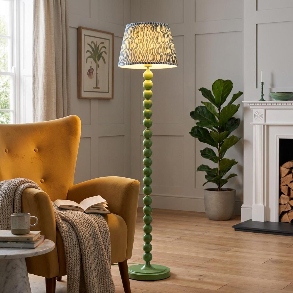Green bobbin floor lamp with a blue ripple shade in a cozy living room next to a yellow armchair.