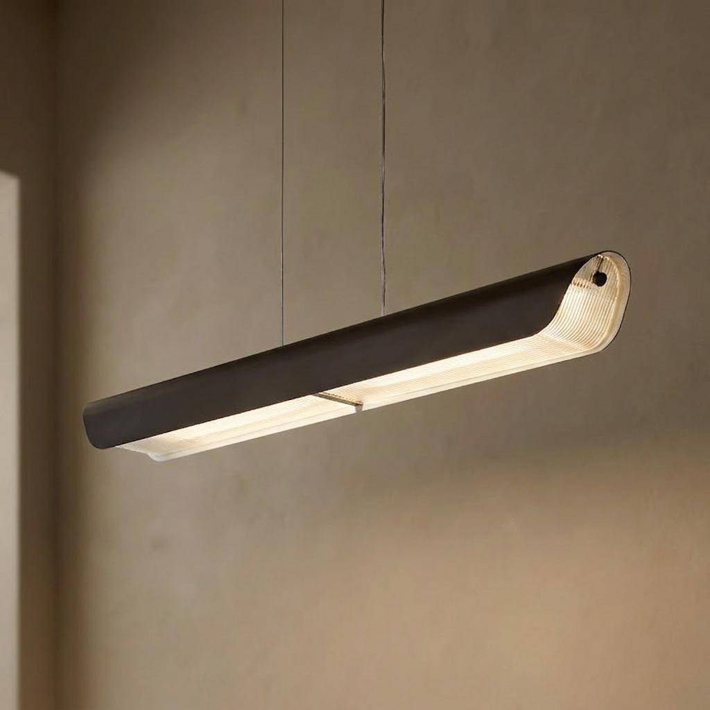 Modern black linear LED pendant light with a sleek curved profile illuminated against a neutral wall.