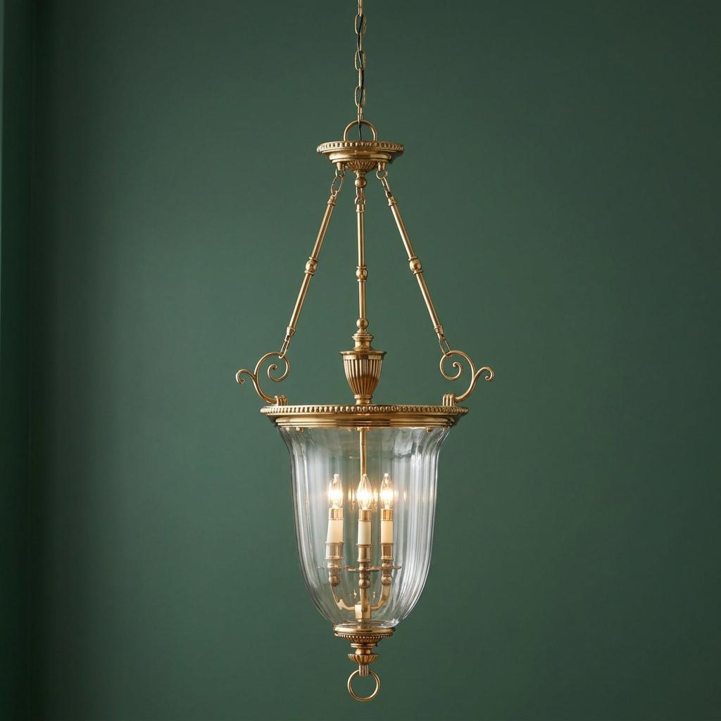Traditional brass ceiling lantern with clear ribbed glass and three candle lights against a dark green wall.