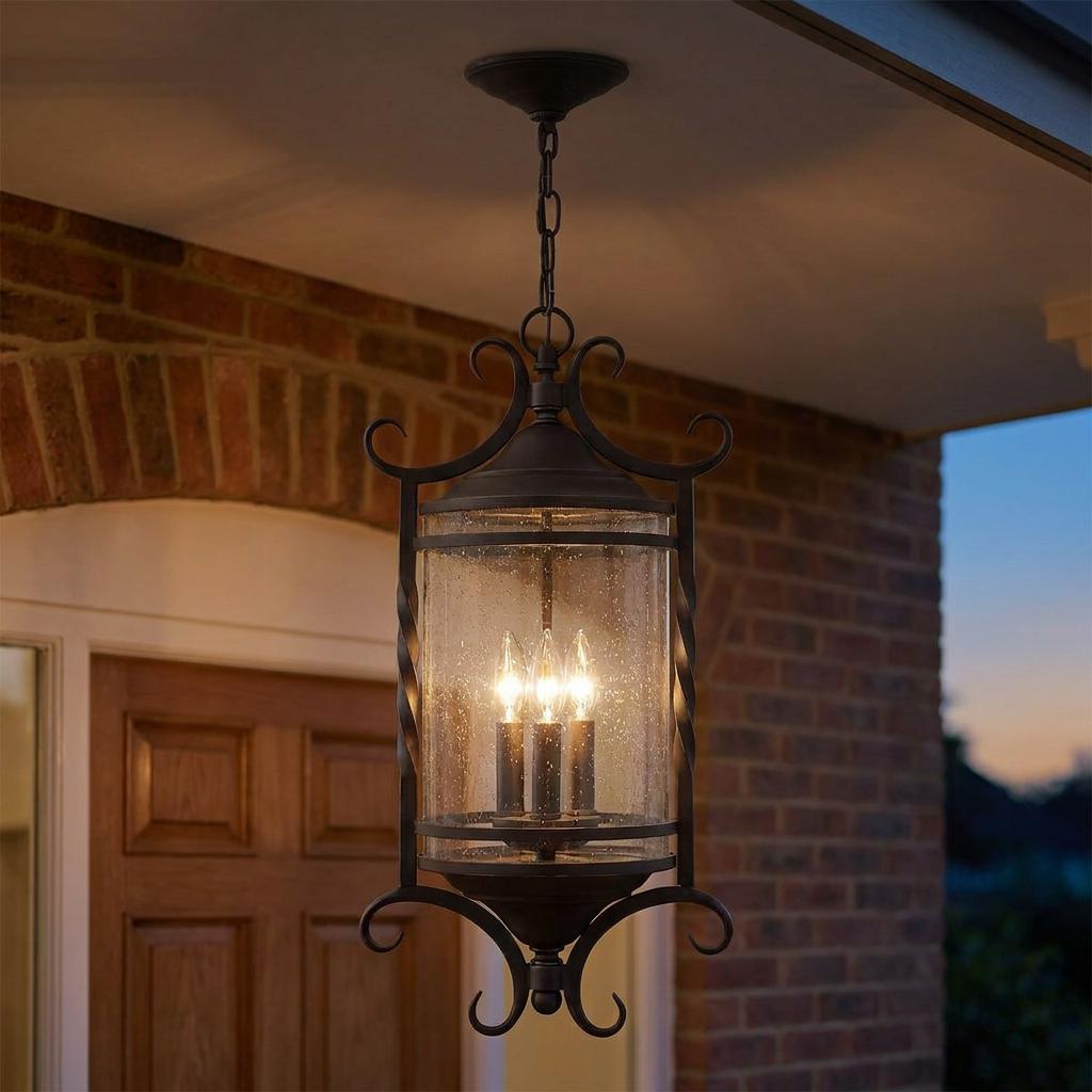 Hinkley Casa black outdoor lantern with seeded glass and scrolls hanging from a porch ceiling at dusk.