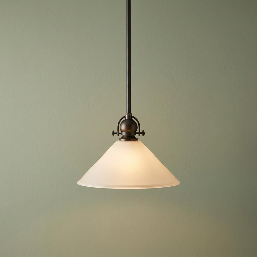 Bronze pendant ceiling light with a conical etched white glass shade against a soft green background.