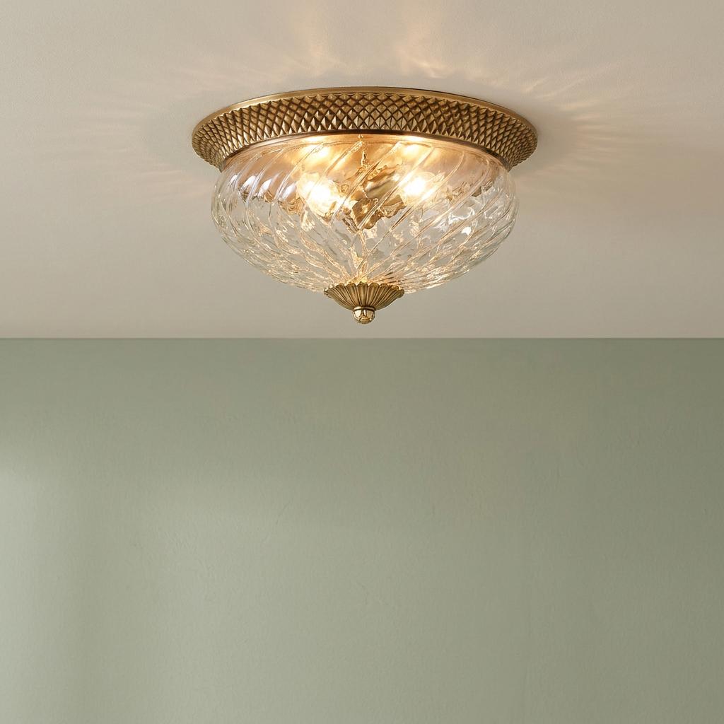 Hinkley Plantation 3 light brass flush mount featuring clear optic glass and decorative brass rim on a ceiling.
