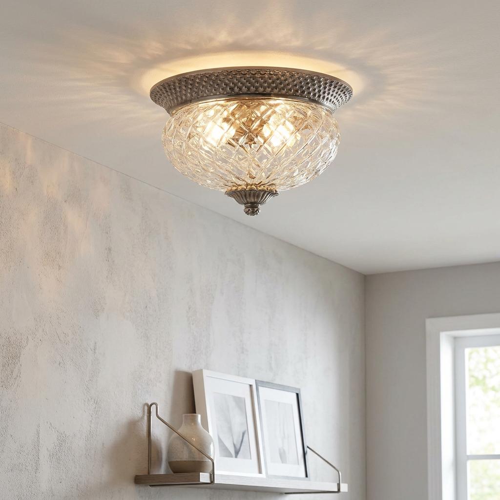 Pineapple-style clear glass flush ceiling light with a nickel base glowing in a modern room.