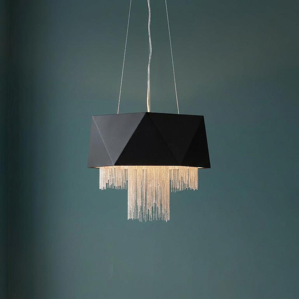 Geometric black faceted pendant light with tiered silver chain fringe against a teal wall.